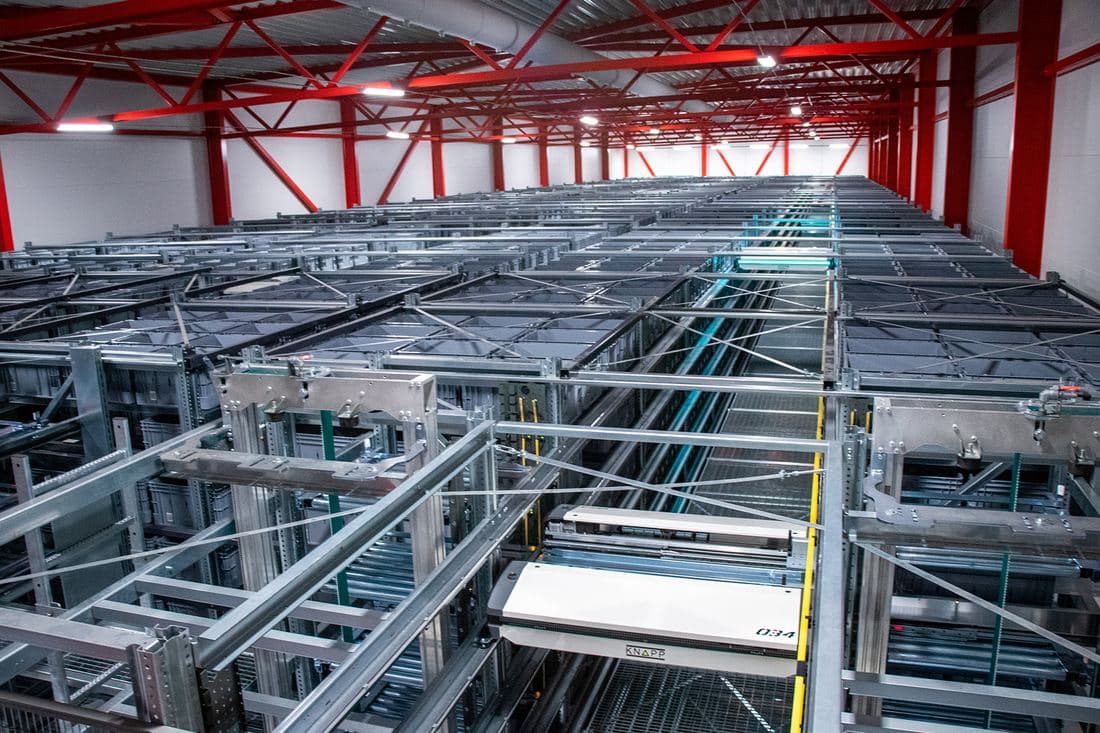 An automated warehouse of conveyors and robotic storage lanes