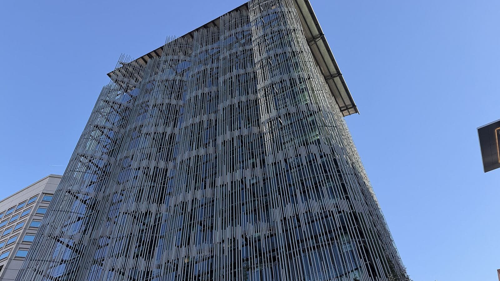 The glass facade of a government administrative building seen from below