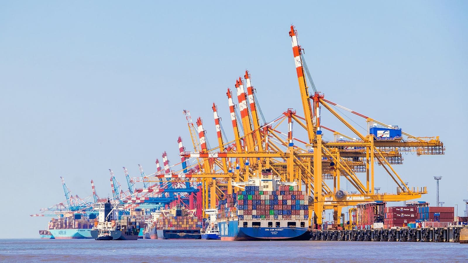 Gantry cranes loading containers onto a ship at a freight terminal