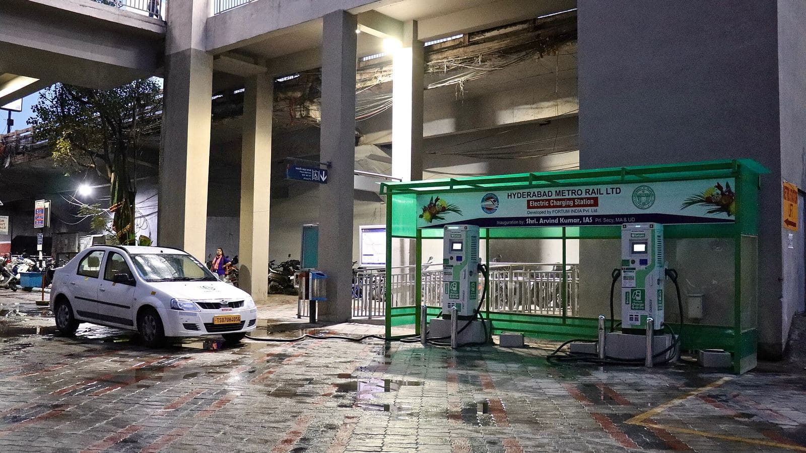 An electric vehicle charging station lit at night under a canopy