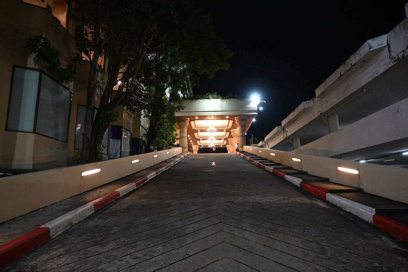 A vehicle barrier at the mouth of a lit access ramp at night