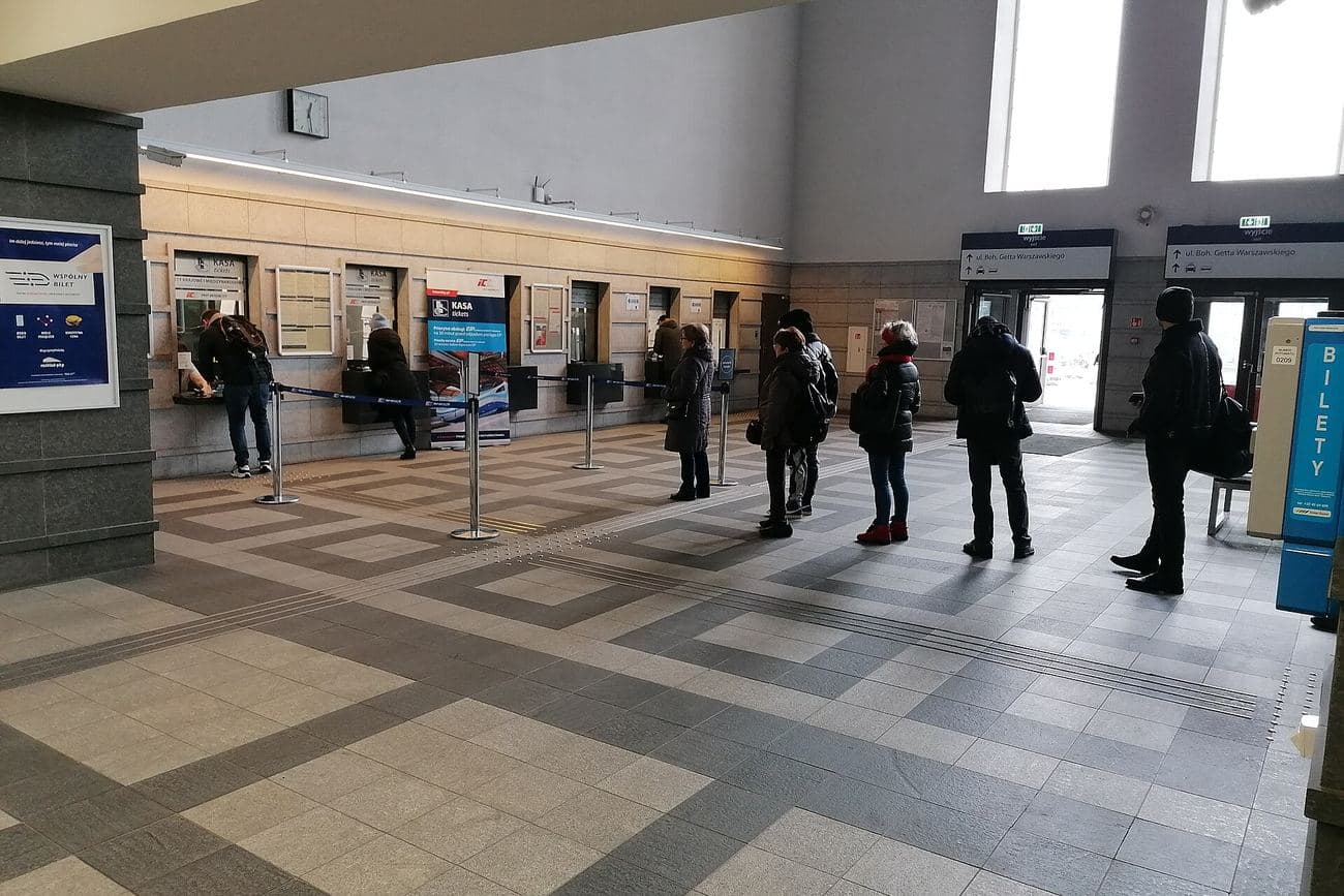 People queueing at self-service kiosks in a public service hall