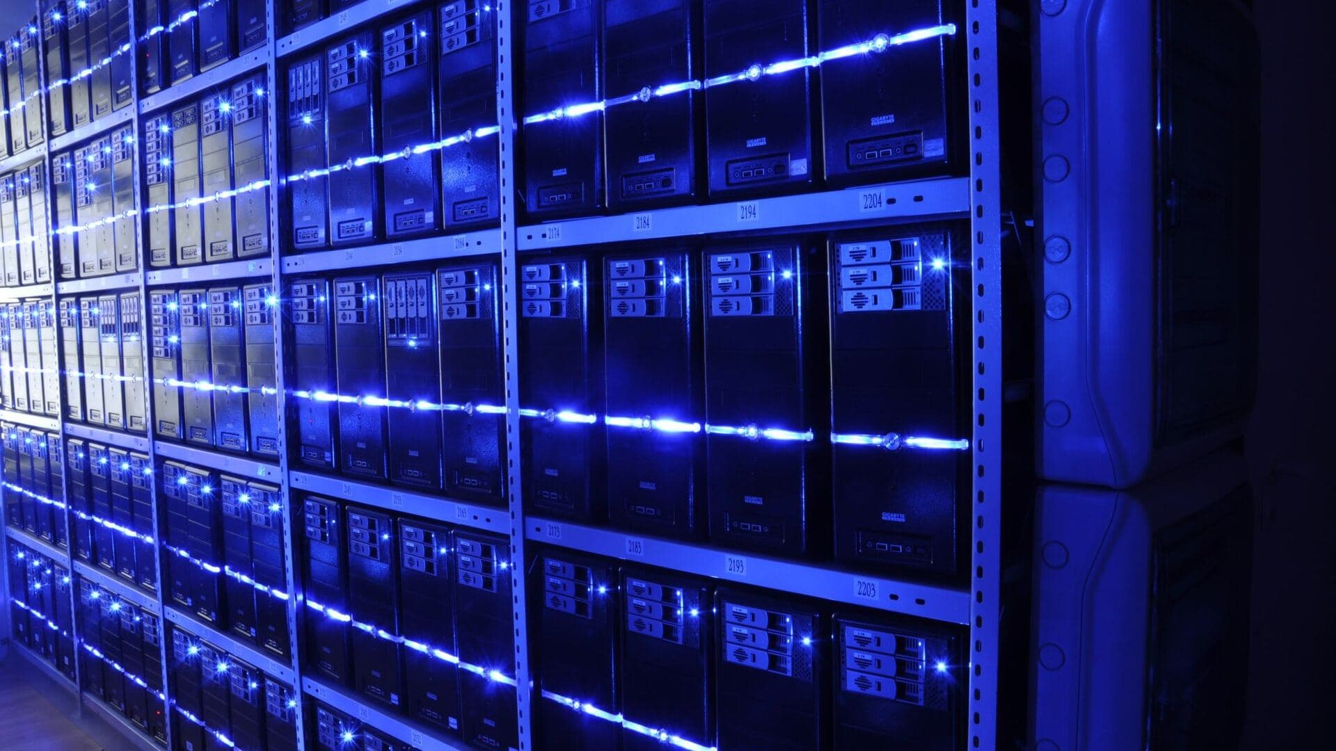 Rows of server racks in a data centre, lit by blue status indicators